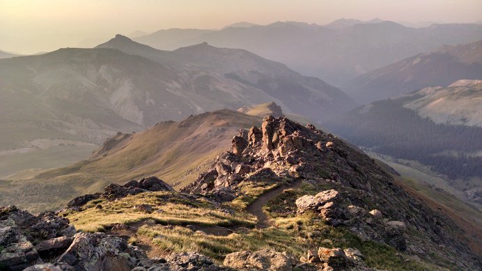 Looking down into the Matterhorn Creek valley from Wetterhorn Peak's southeast ridge at sunrise with Broken Hill beyond