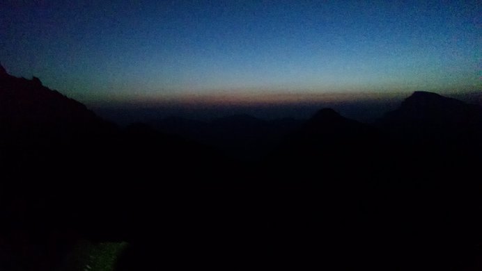 The first dim red glow of sunrise in the San Juan mountains