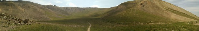 A wide-angle panorama of the green basin below Redcloud Peak