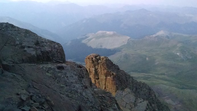 A geological feature on Wetterhorn Peak called "the Prow" with green valleys to the west